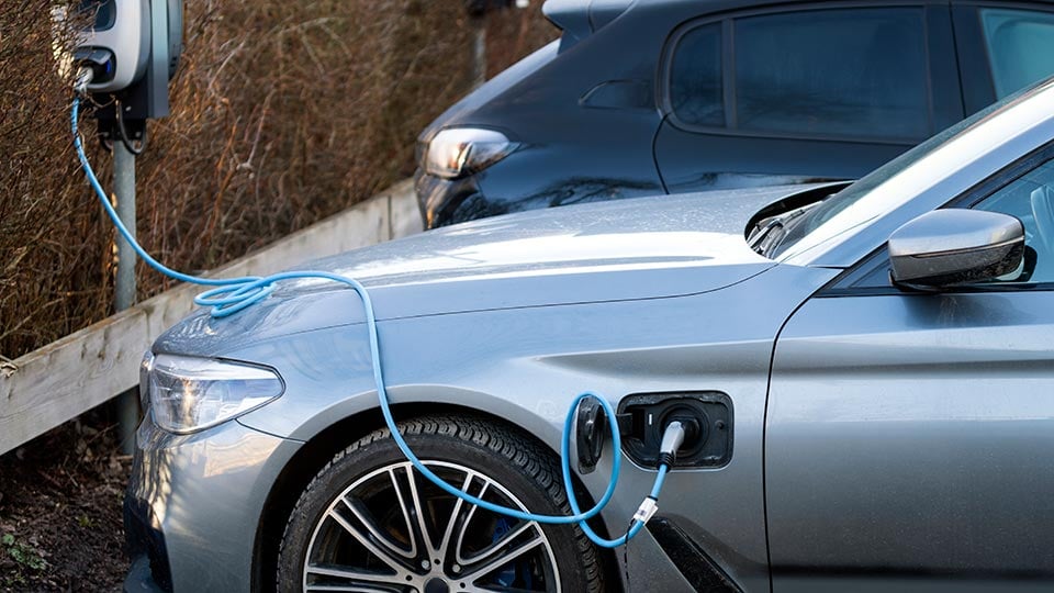 Elbil laddar på parkeringsplats med laddstolpar, Järfälla, Stockholm