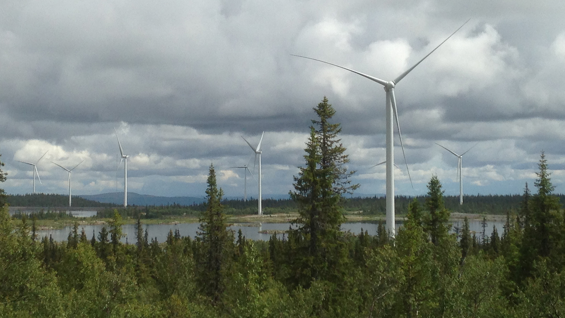 Fotograf: Johan Svensson Vindkraftspark i landskap av skog och sjö.