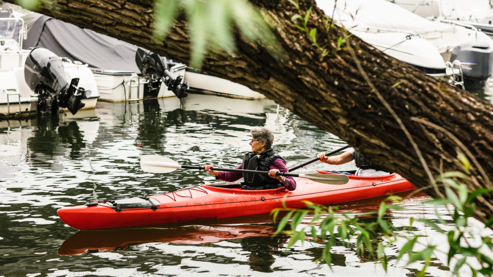 En kvinna och en man lär sig paddla tvåmanskajak