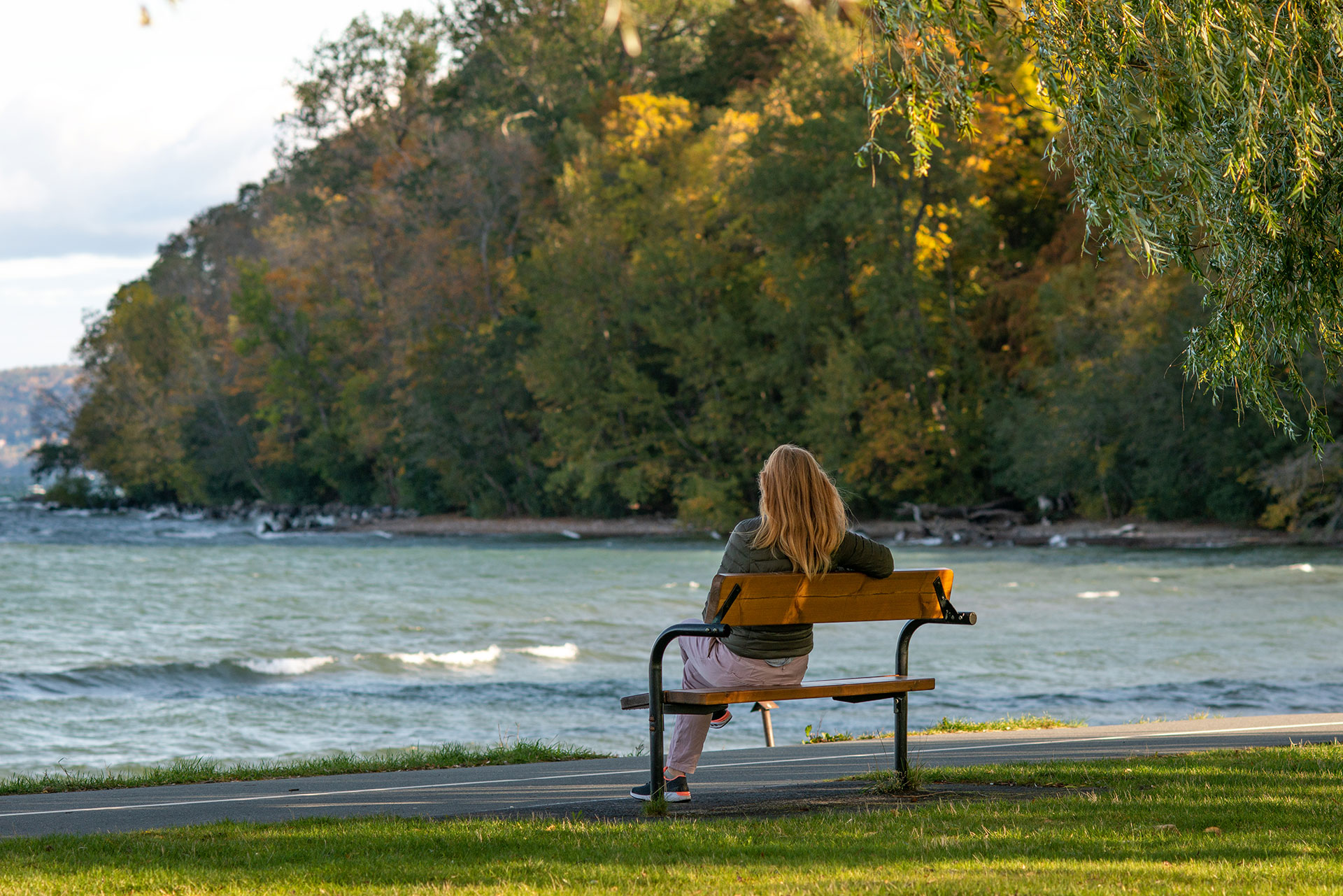 Fotograf: Peter Appelin Kvinna på en parkbänk vid stranden av Vättern, Jönköping