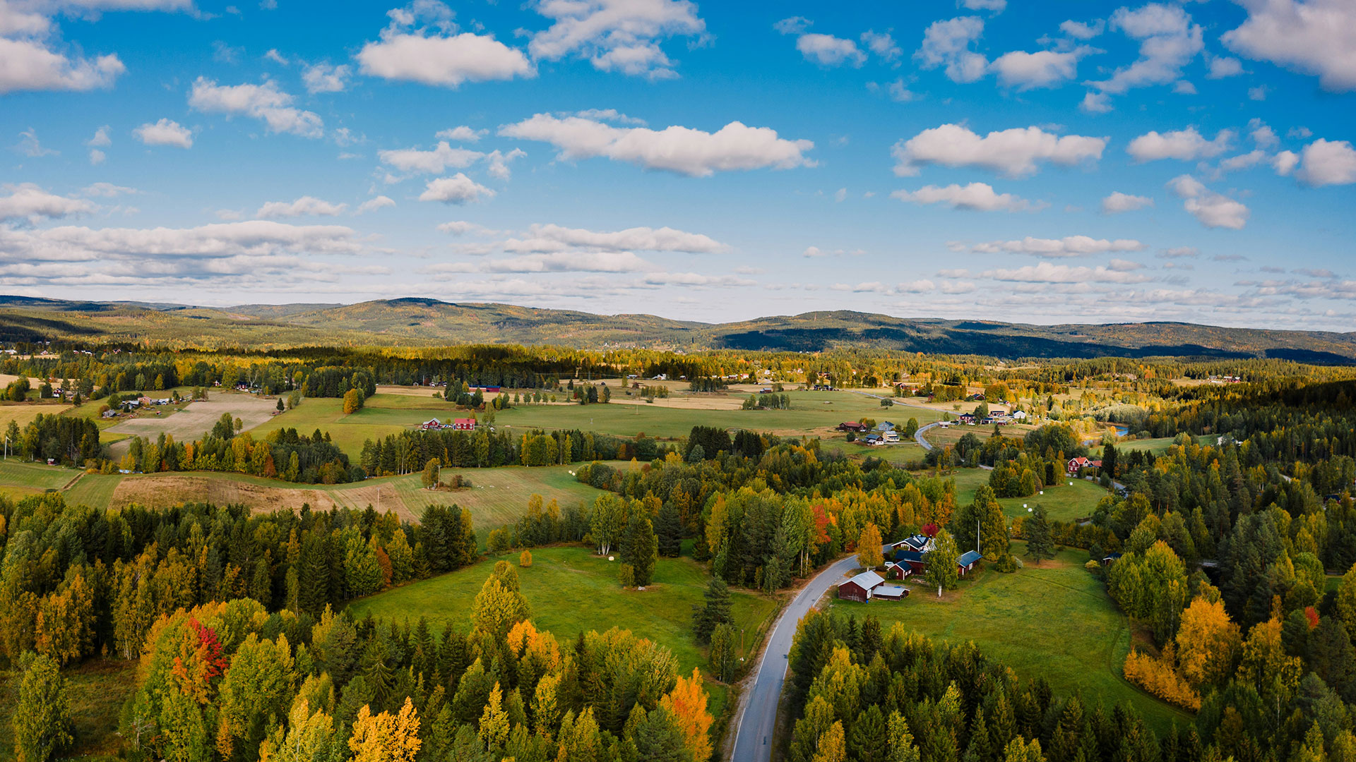 En vy över landskap i Stöde med berg och blå himmel i bakgrunden